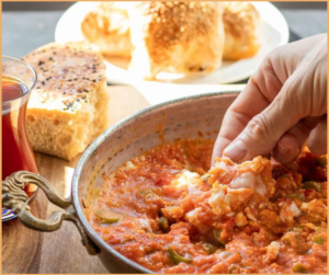 Turkish Menemen”, a hearty breakfast dish, blends scrambled eggs with tomatoes, peppers, onions, and spices, creating a flavorful and comforting meal